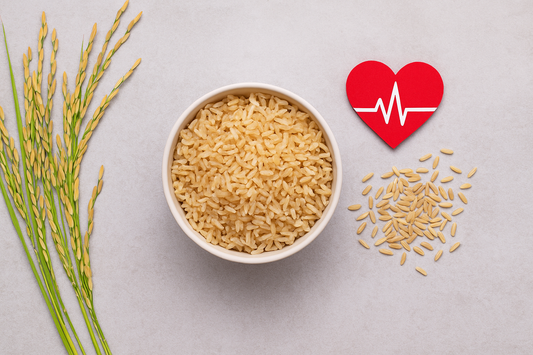 Bowl of cooked brown rice beside rice stalks